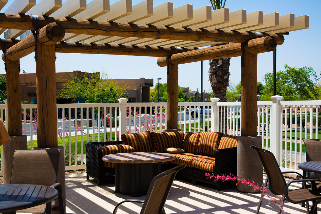 Poolside gazebo with comfortable L shaped outdoor cushioned couch and coffee table.