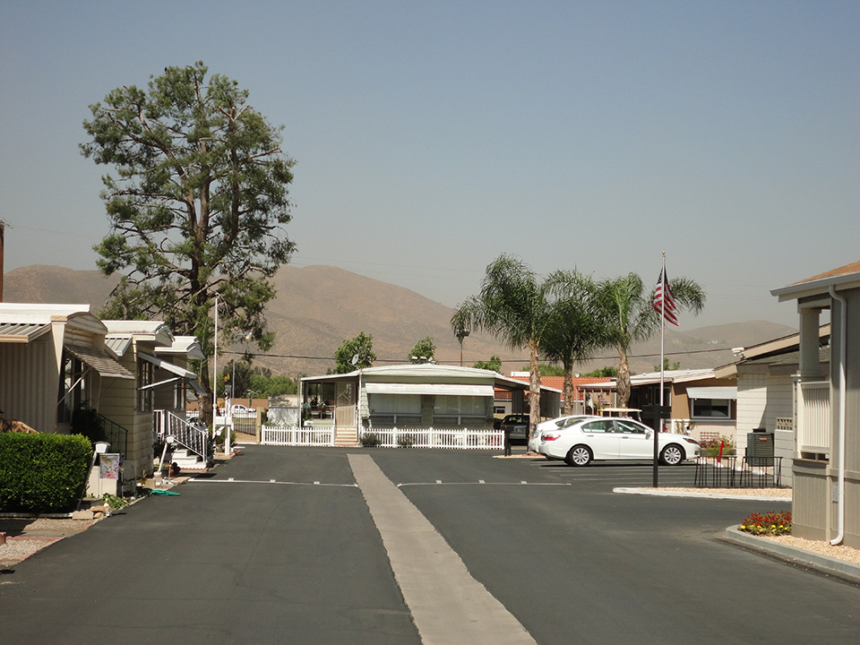 Bel Air Estates, an active 55 plus community in Menifee, California has wide, clean paved streets. Rolling hills in background.