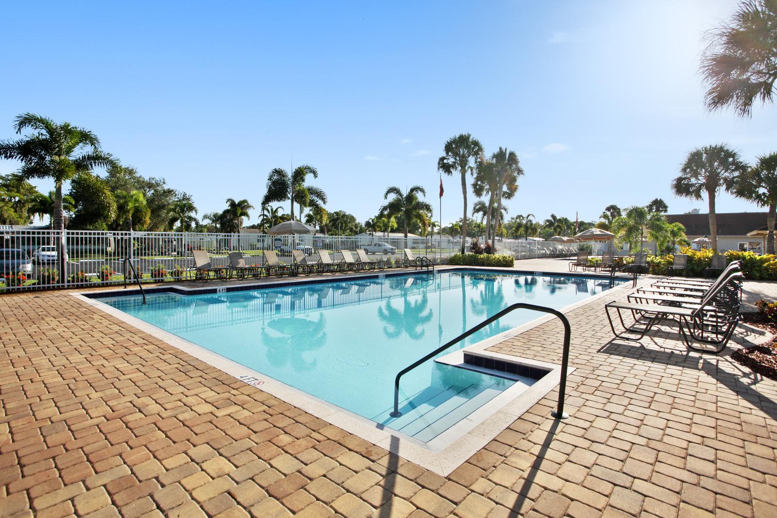Fountainview Estates, an active 55 plus community in Tampa Florida with clean pool and lounge chairs surround pool area.