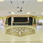 Large, spacious clubhouse that host many community wide events. A disco ball hands in the middle of the floor and 2 decorated Christmas trees sit at each side of the stage.
