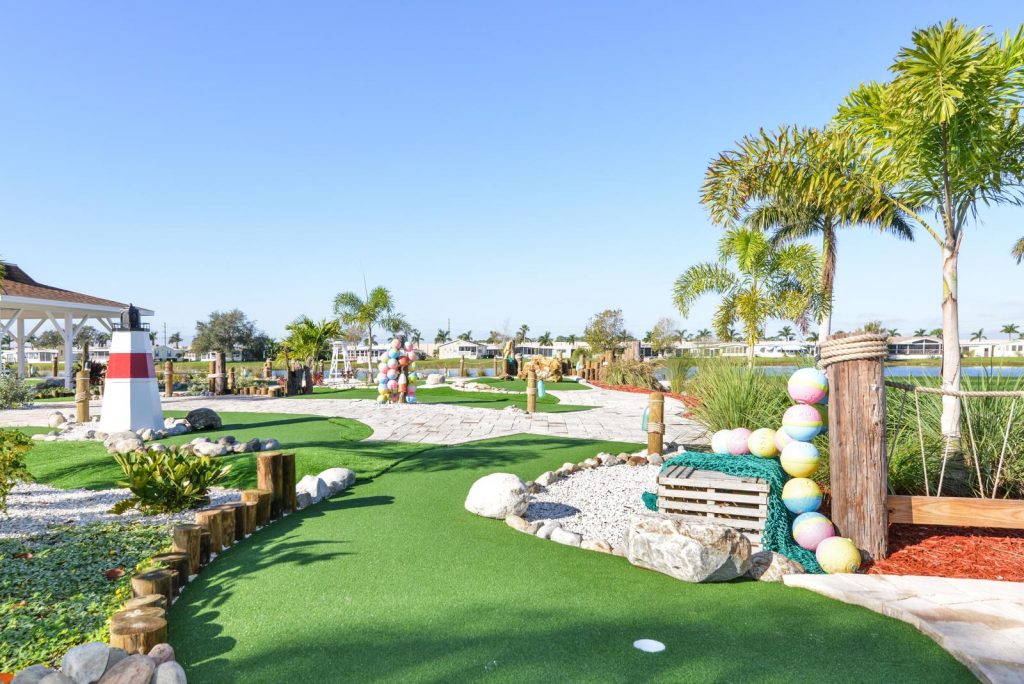 Beautiful miniature golf with fresh greens along the course. Palm trees planted throughout. Natural lake in the background.