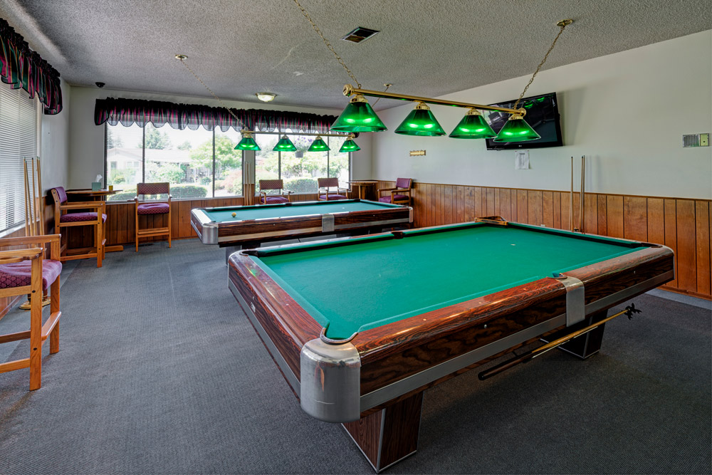 Billiards room with 2 pool tables. Seating along the wall.