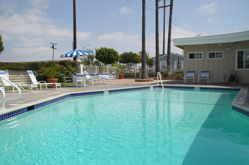 Outdoor community pool available for parties and events hosted by residents. Surrounded by chairs and tables for seating.