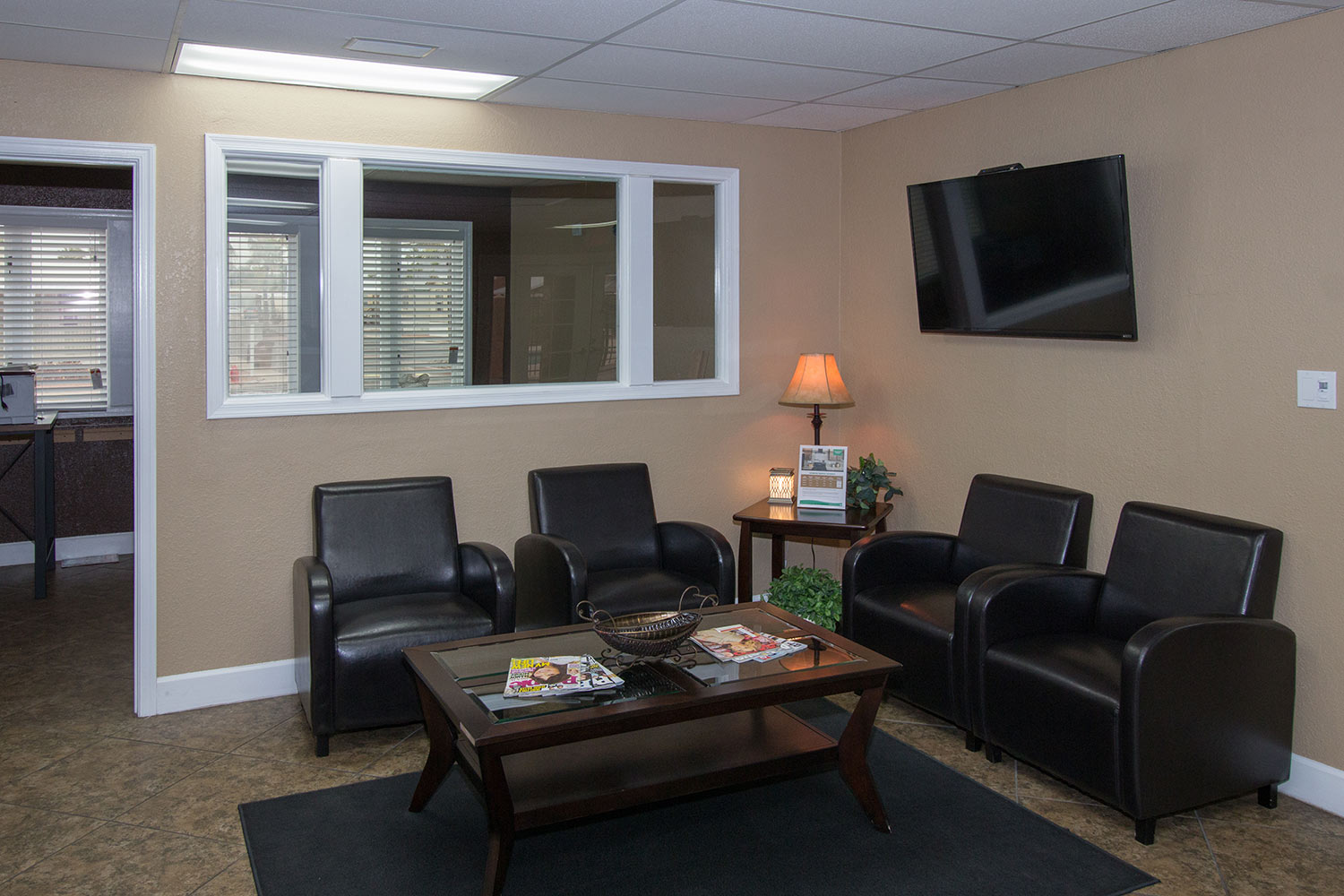 Lounge area in clubhouse with comfortable leather chairs and flat screen TV on wall