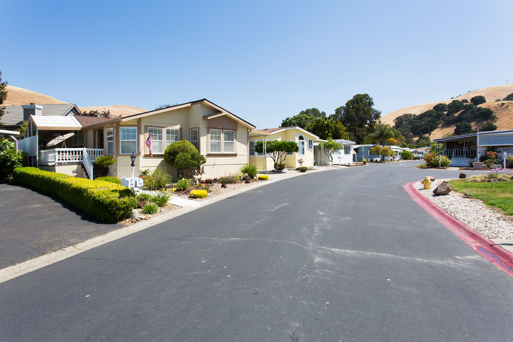 Wide, paved streets are lined with beautiful manufactured homes. Each home has a well-maintained, green front landscape