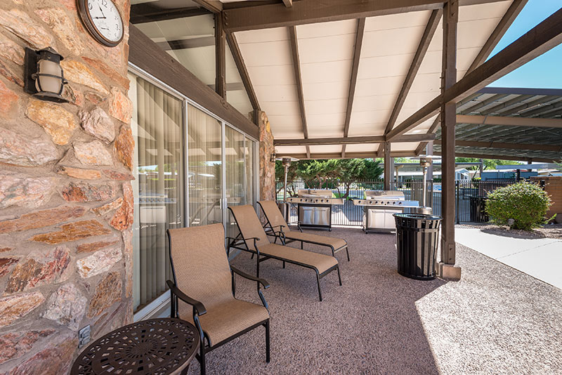 Relaxing outdoor shaded area outside of the community center. Access to two large gas barbeques, lounge chairs and a 3 piece seating set.